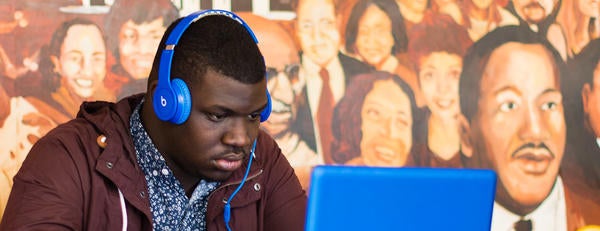 ASP student studying with headphones and laptop.